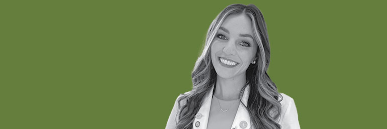 A woman in a white coat against a green background.