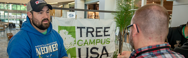 NEOMED employee handing out tree seedlings