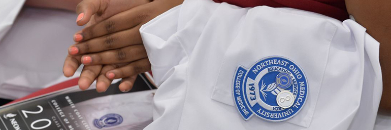 Student holding White Coat