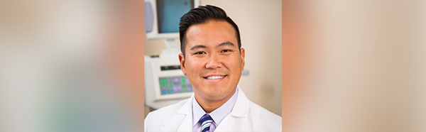 Timothy Ko headshot wearing white coat with purple shirt and purple tie