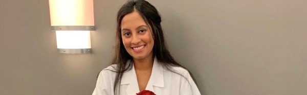 Payas Shah in her white coat holding a rose