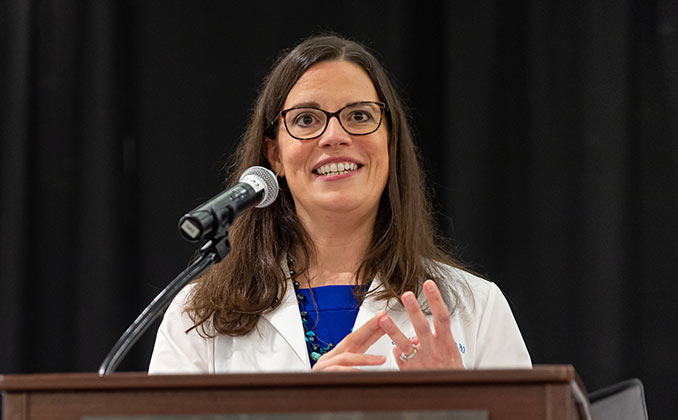 A doctor speaking at a lectern.