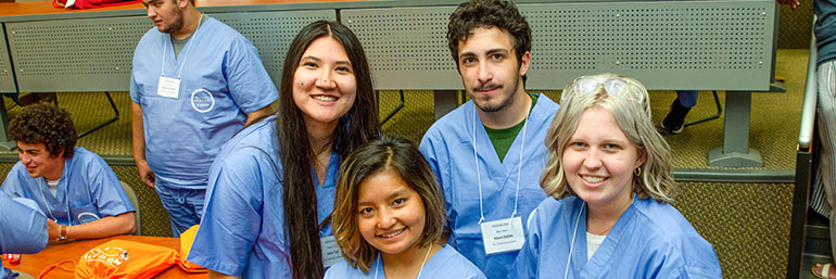 Four MEDCAMP students appear in medical gear.