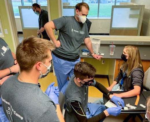 An assistant professor acts as a patient in the IV lab.