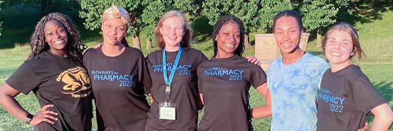 Six female campers stand in a line during Pathway to Pharmacy summer camp.