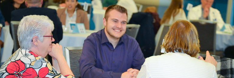 A student smiles while talking with two physicians during the specialty speed dating event on the NEOMED campus.