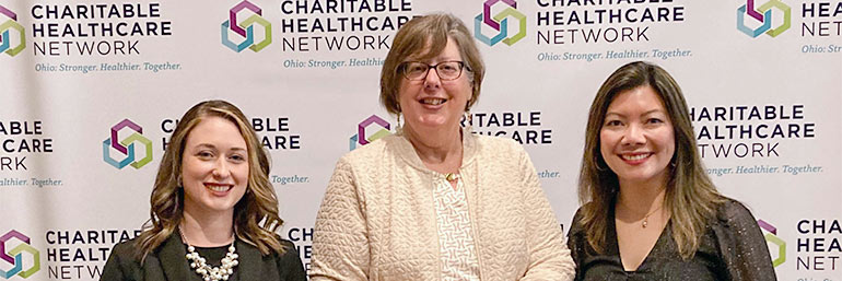 Three women holding awards for their work at NEOMED's free clinic.