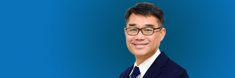 Tom Vo, a NEOMED graduate, on a blue background.